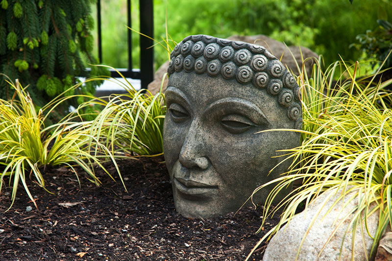 A statuary head is emphasized with bright gold grasses.