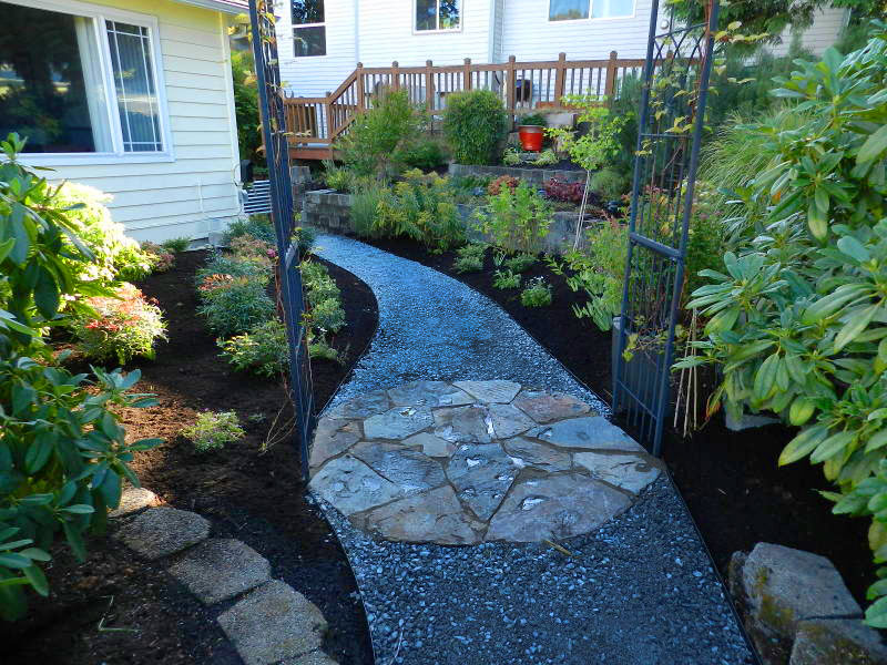 Natural stone pavers set in a circle are a functional work of art in the middle of a gravel pathway.