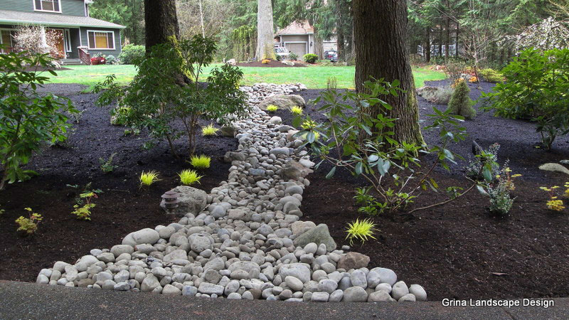Dry creek beds break up large landscape beds into smaller, more interesting spaces.